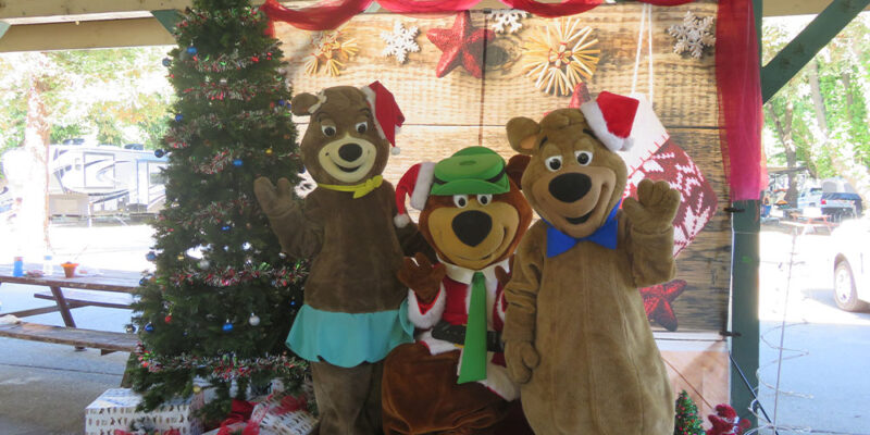 Yogi Bear, Boo Boo Bear, and Cindy Bear are dressed in festive holiday attire.