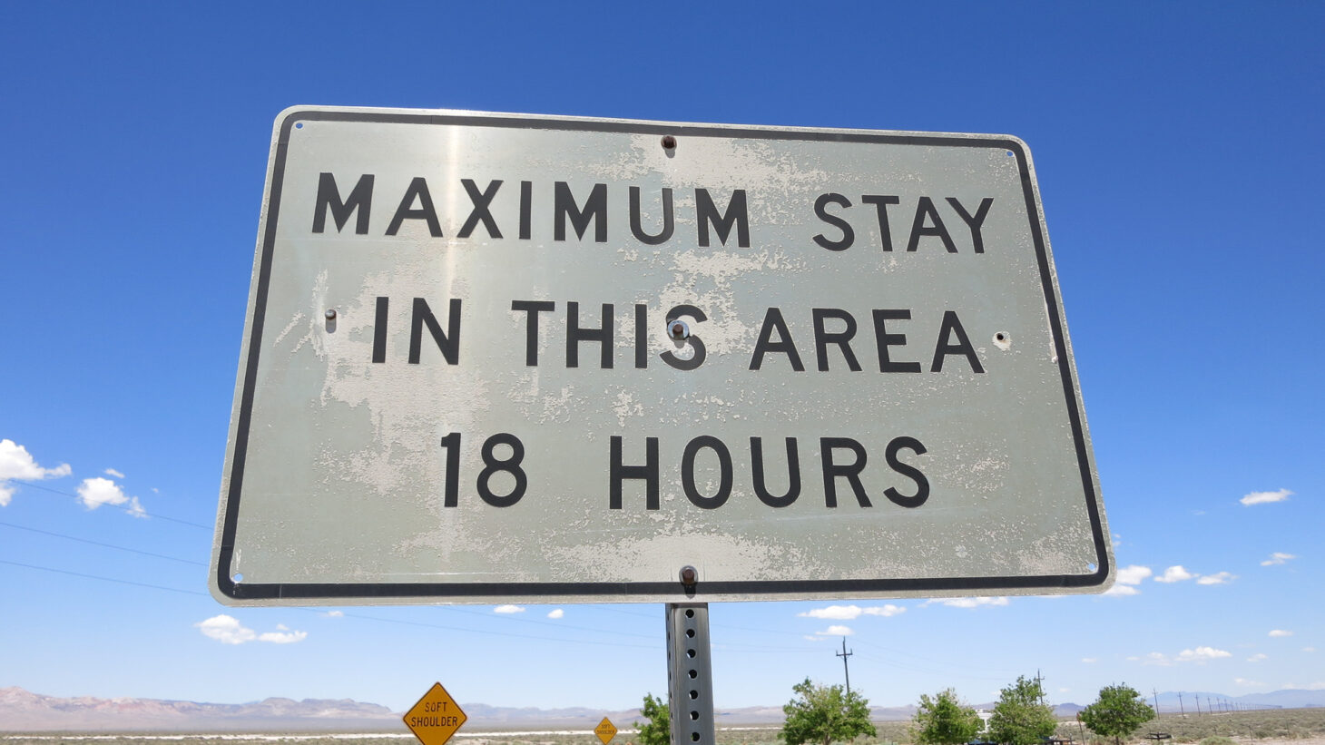 Sign at rest stop reading "Maximum stay in this area 18 hours"