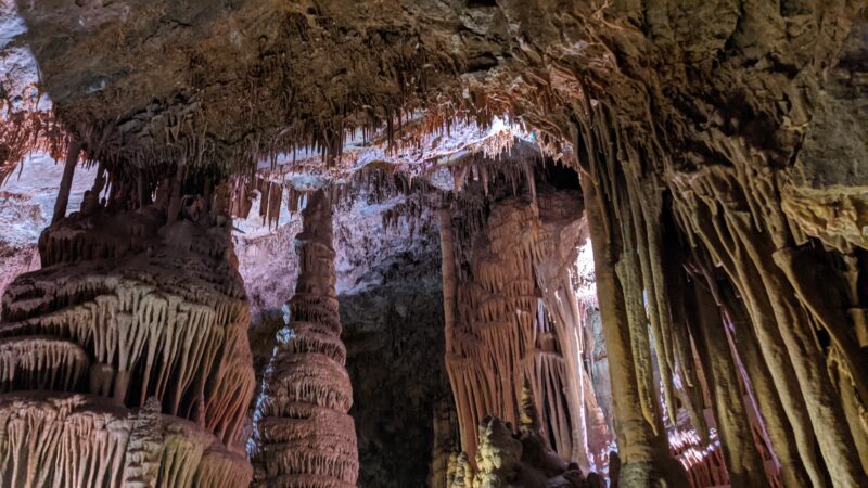 The inside of a striking cavern reveals stalagmites and stalactites.