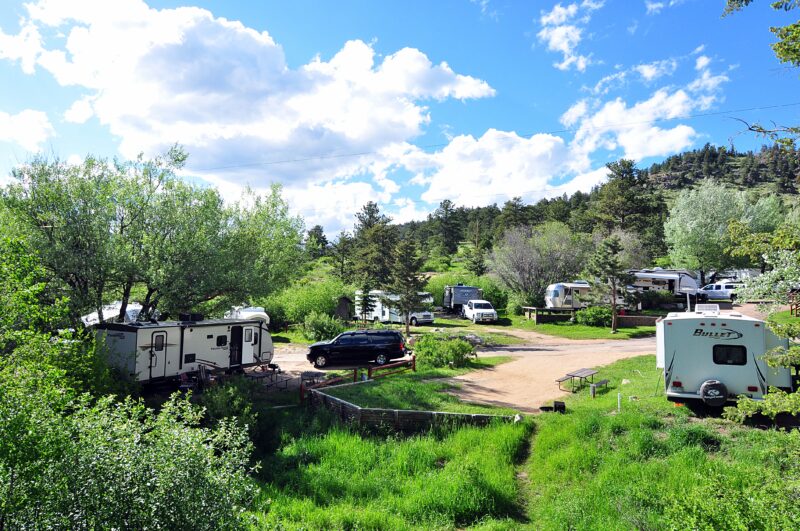 A variety of RVs sit in a hilly campground in Colorado.