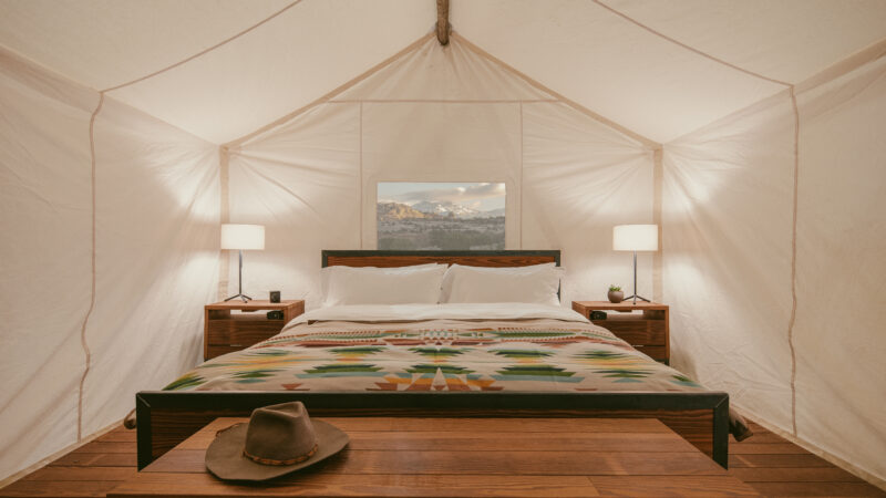 The inside of a luxury tent at ULUM Moab features plush bedding