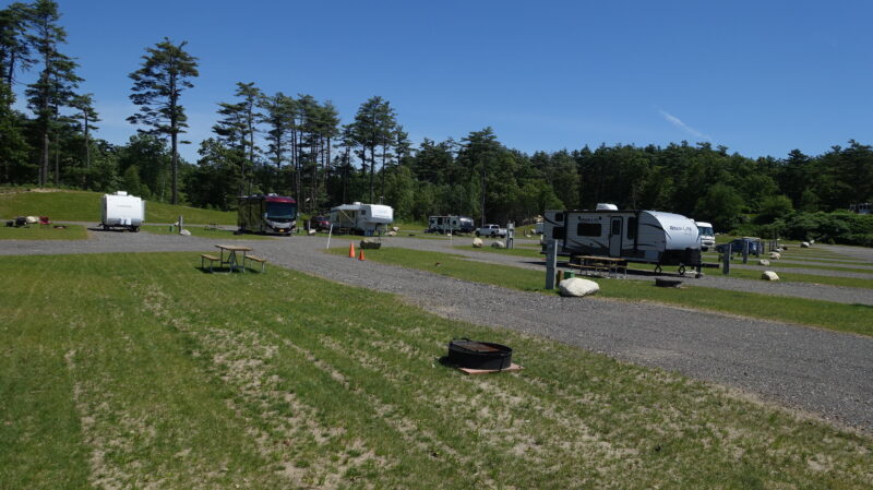 RVs are parked on spacious lots with fire rings at Yogi Bear’s Jellystone Park Camp Resort: Carver Acres in Carver, Massachusetts
