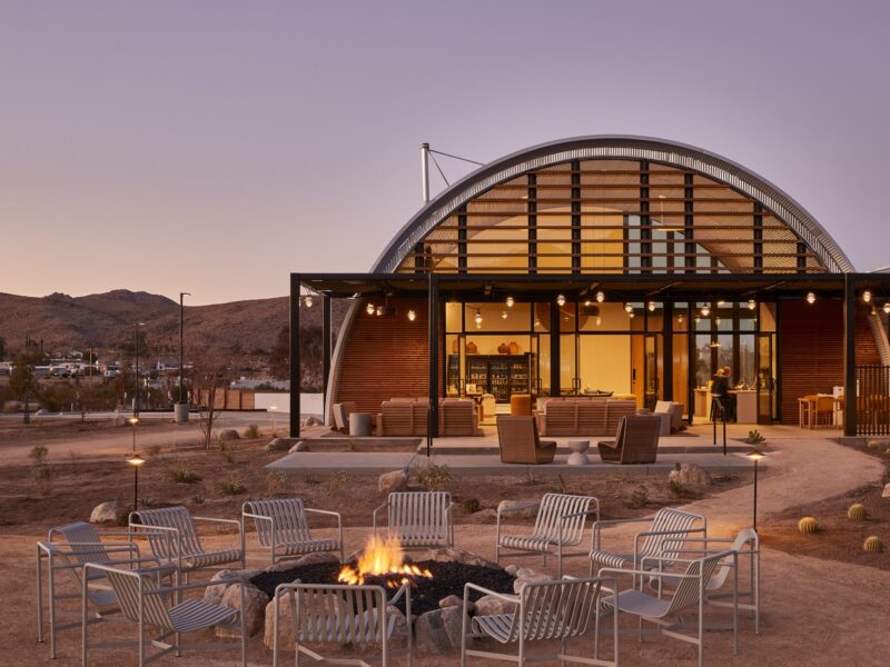 Dome-shaped clubhouse in the desert with a fire pit out front