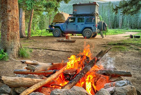 Jeep with rooftop tent and campfire.