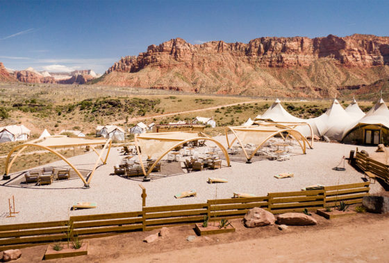 Lounge chairs under cabanas surrounded by canvas tents and Utah's red rocks.