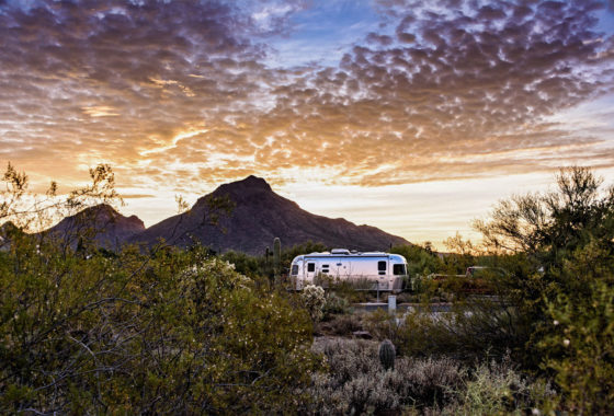 Airstream parked in the desert at sunset.