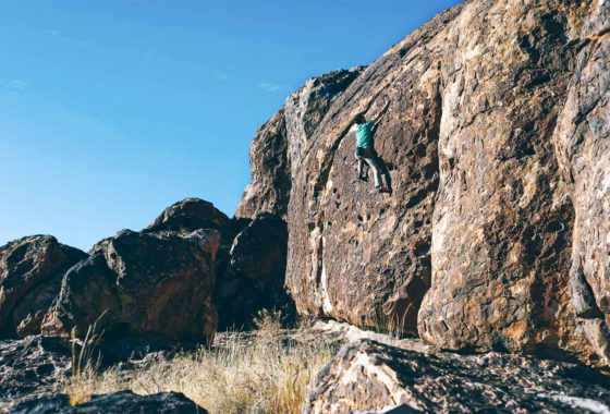 Person climbing up a rock wall.