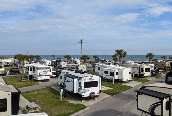 Rows of RV at an RV park right by the ocean.