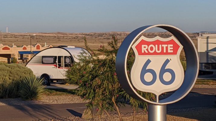 Route 66 signage with a teardrop trailer parked in the background