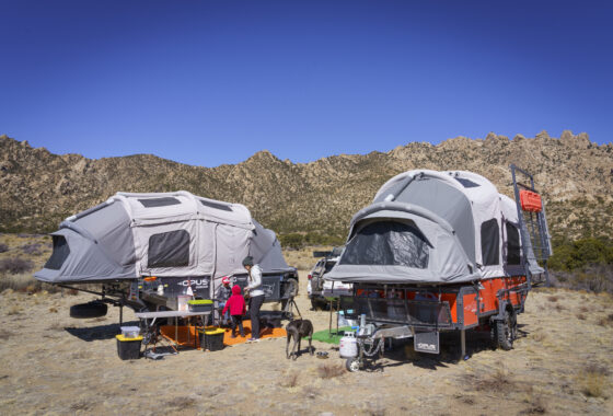 Two overloading rigs set ip in a remote location with tents on top.